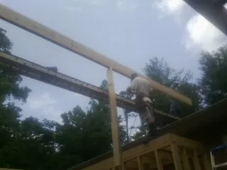Carpenter setting a ridge beam over a new addition frame — Ice Dam Removal by Roofing Brothers in Minnetonka