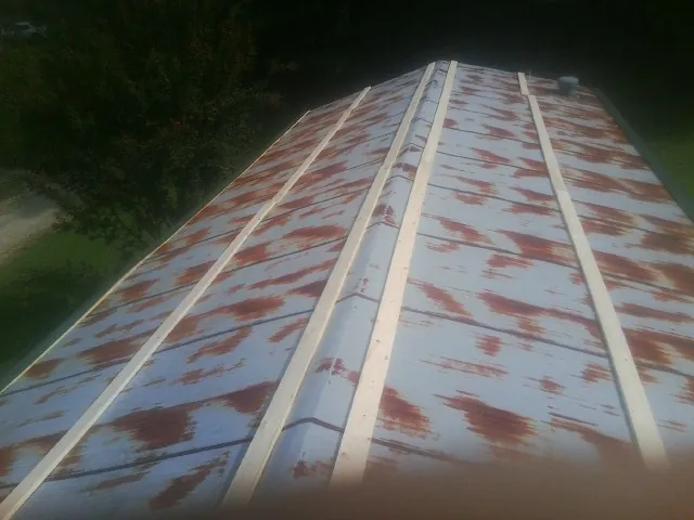 Rusted metal roof panels with new wood purlins before replacement — Storm Damage Roof Repair in Minnetonka by Roofing Brothers